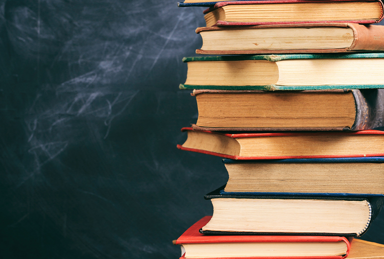 Imagem com uma pilha de livros.