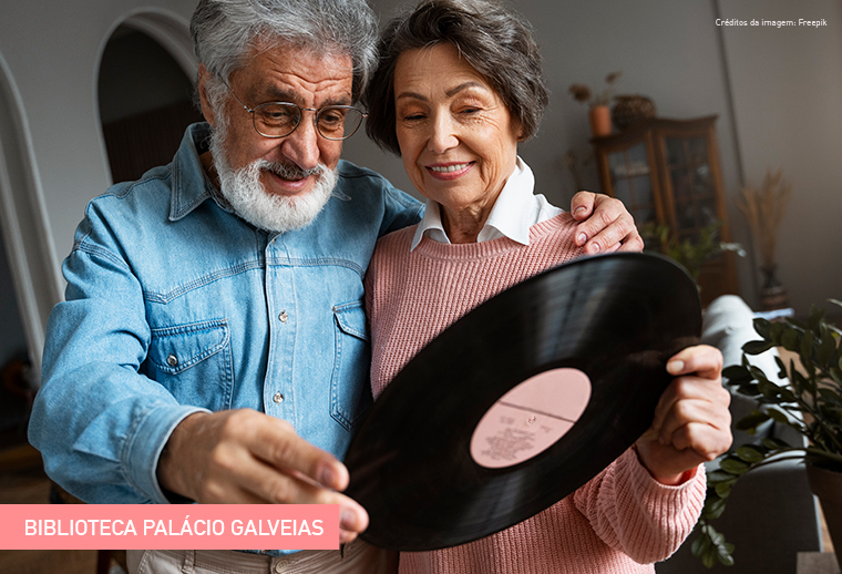 Duas pessoas adultas com um disco de vinil.