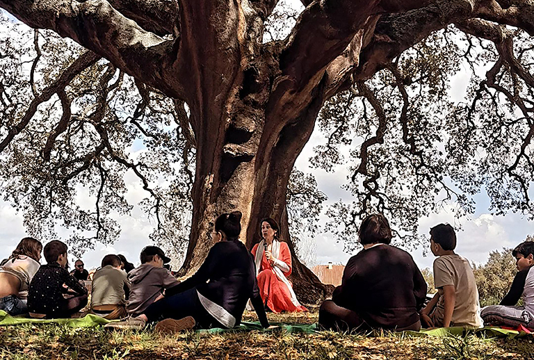 Imagem de uma fotografia com pessoas à volta de uma árvore.