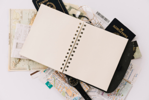 Imagem com caderno em branco e vários folhetos.